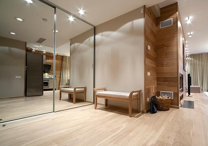 Floor-to-ceiling wall mirrors in a dressing room with wood paneling
