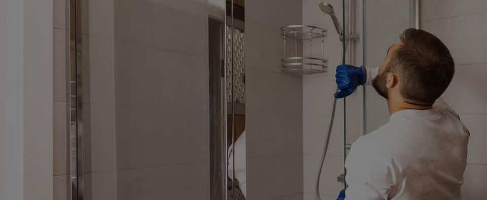 Beacon Glass installer fitting hardware inside a glass shower
