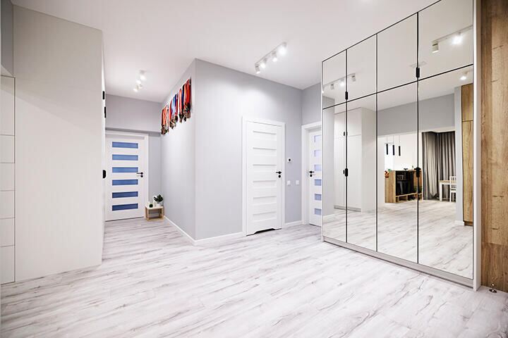 Full-height mirrored closet doors in a bright hallway